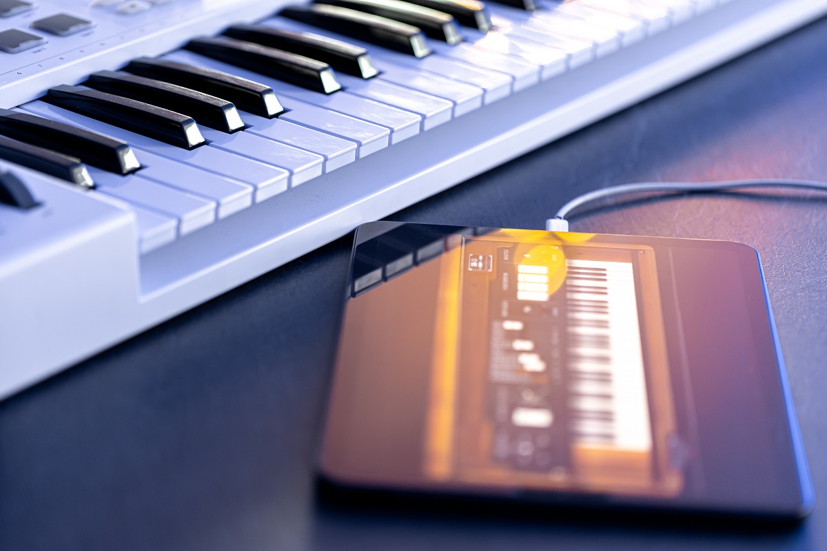 Chaves musicais e um tablet com caneta na mesa